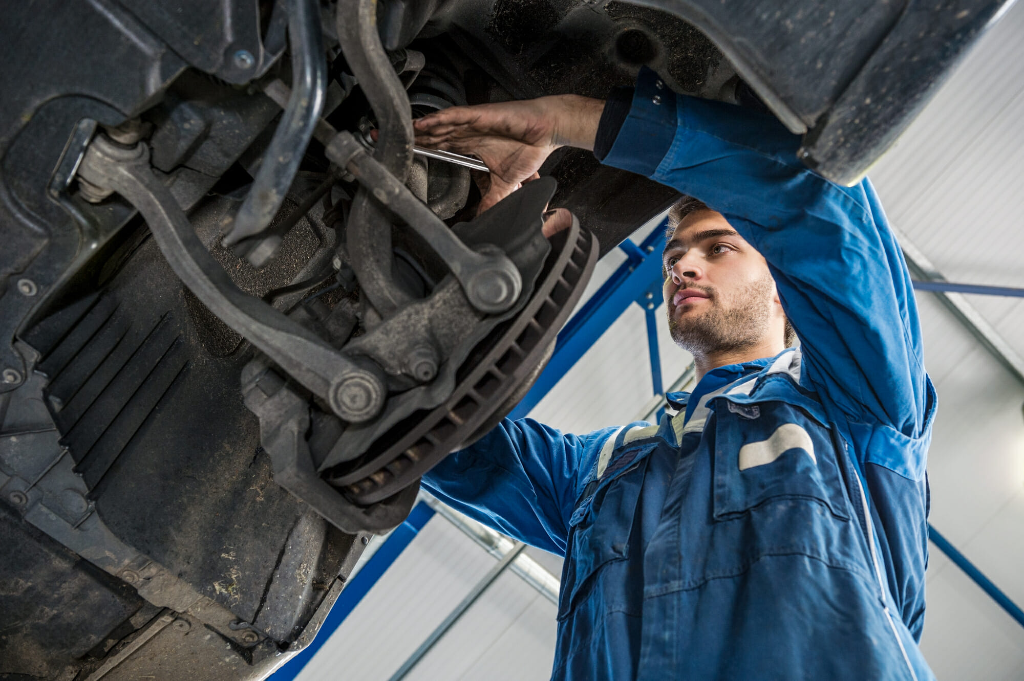Auto Mechanic Repairing Car Suspension