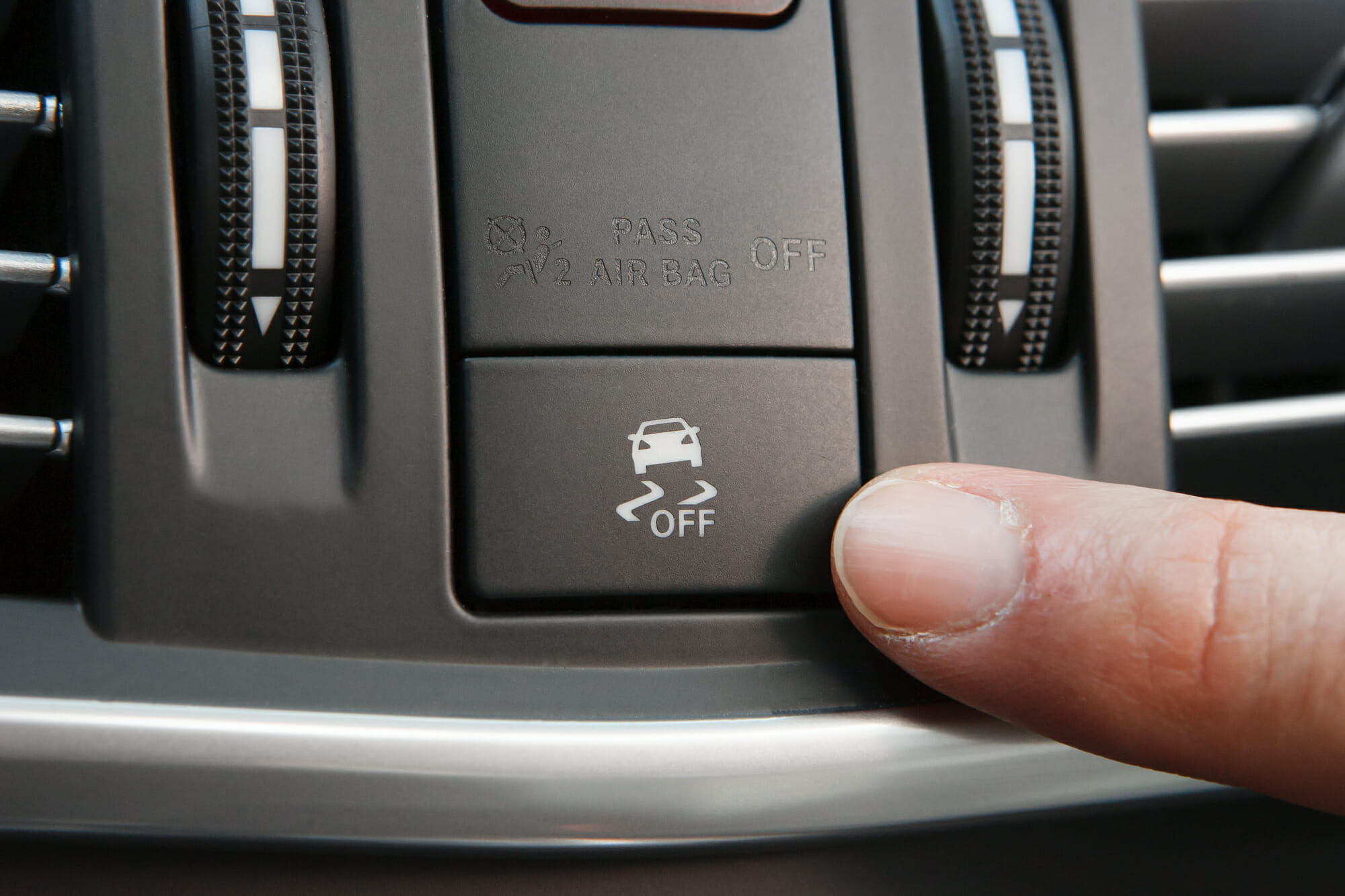 Driver Pointing At Car Traction Control Button