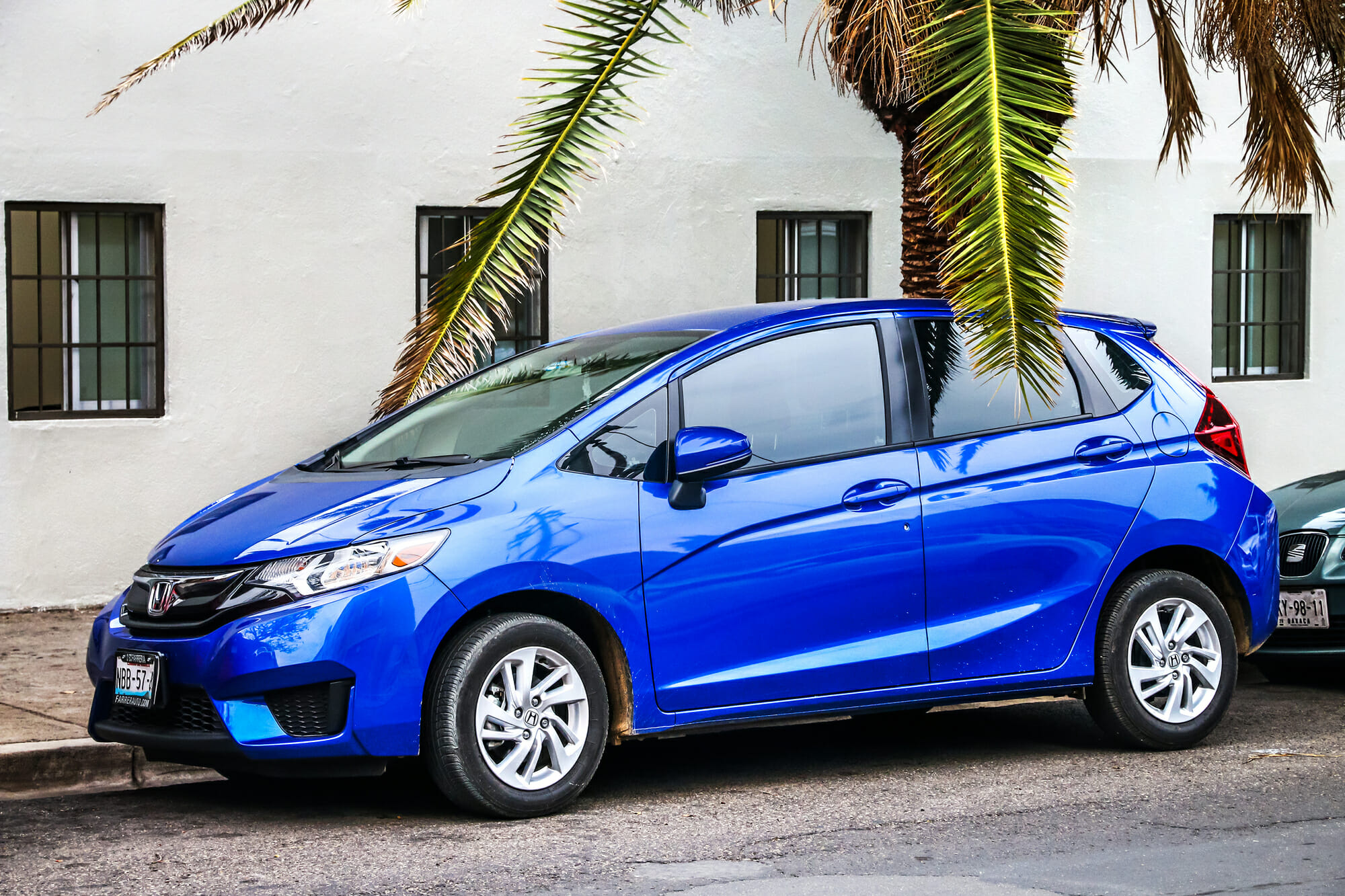 Blue Honda Fit on city street with palm trees - Vehicle History