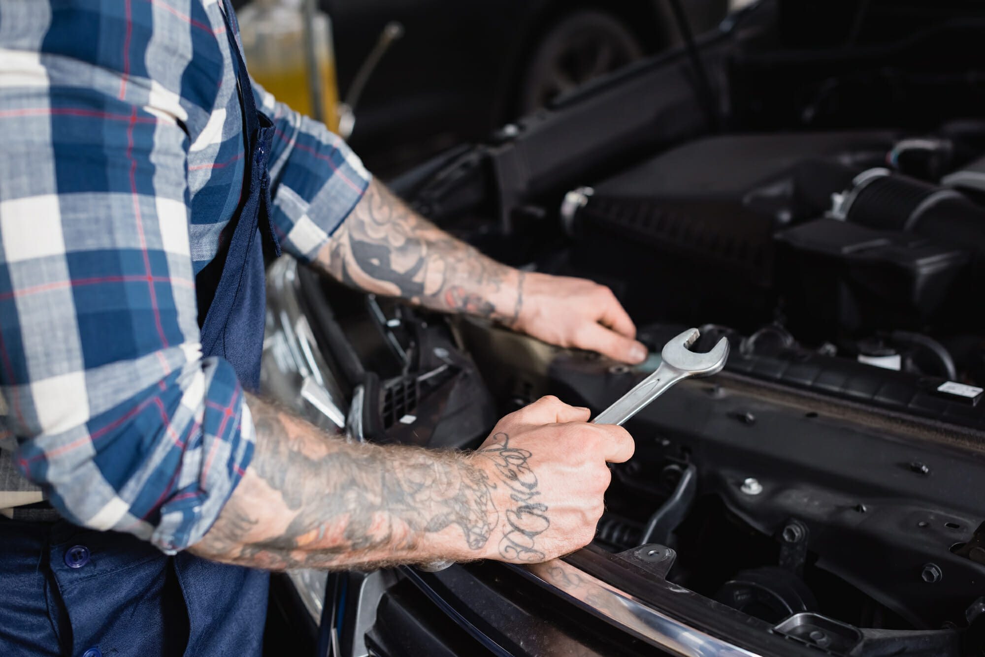 Auto Mechanic Holding A Wrench Near Engine