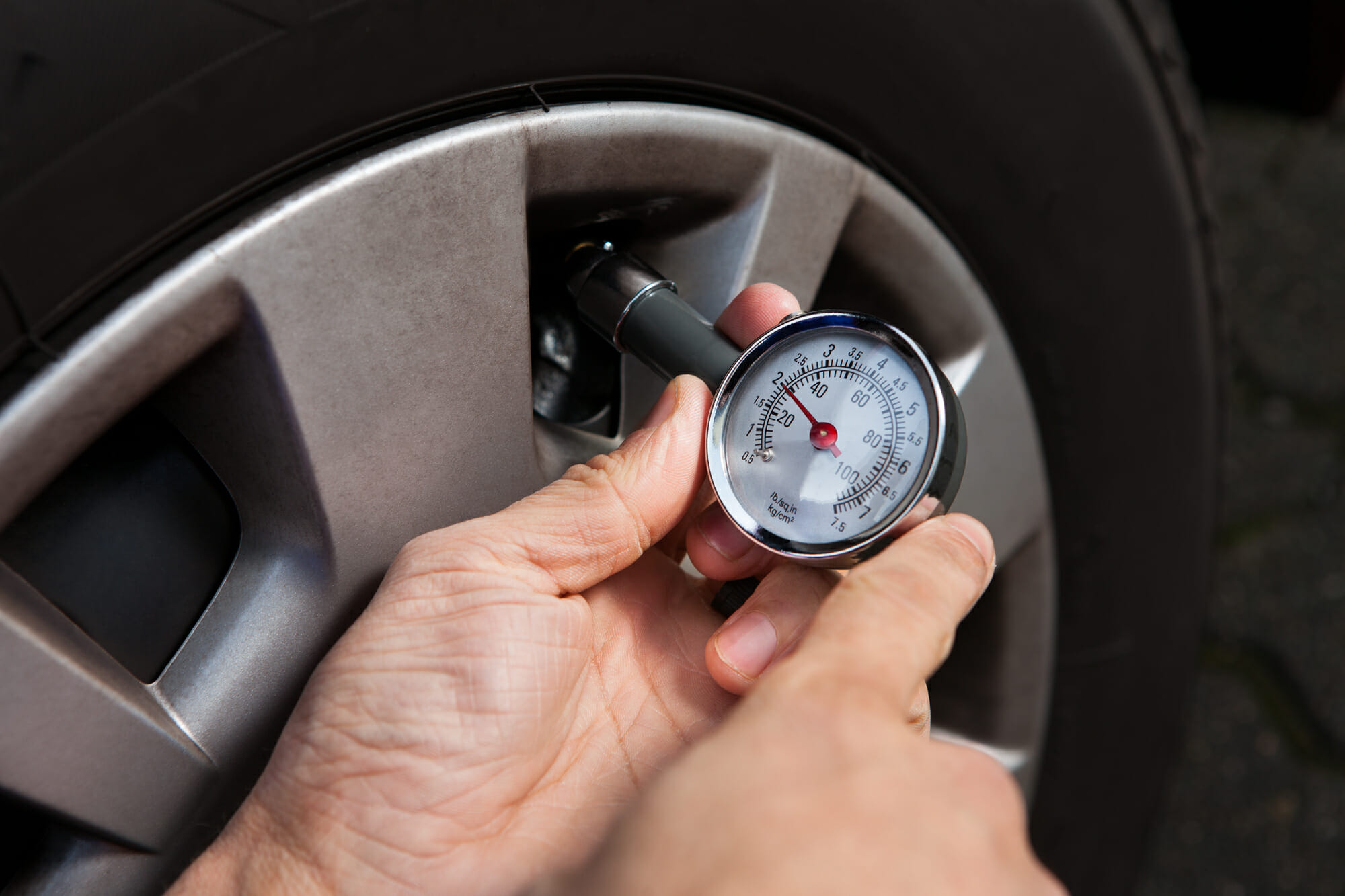 Auto Mechanic Checking A Tire Pressure