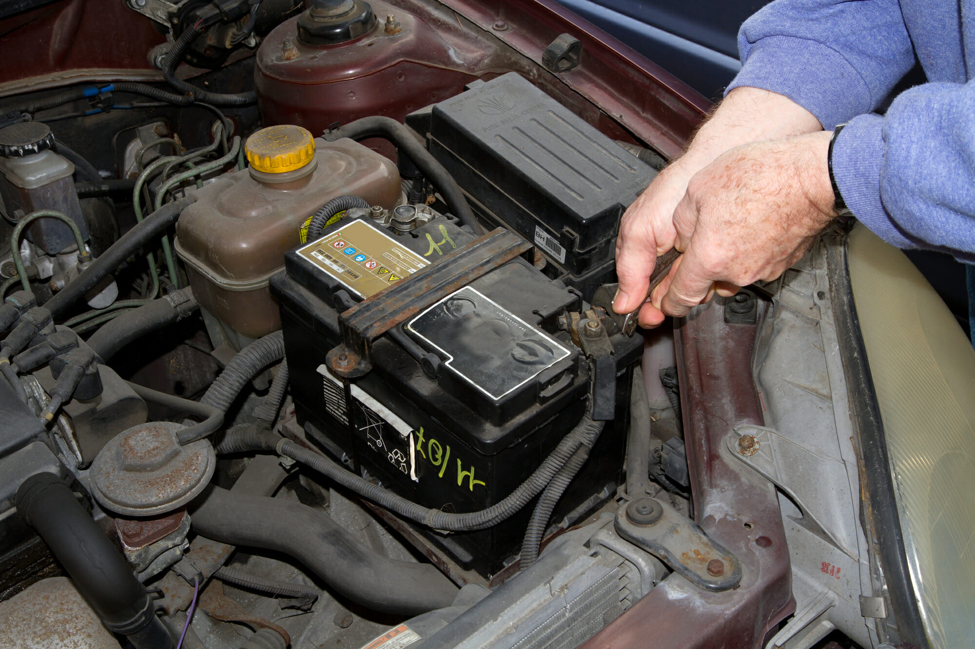 mechanic changing the battery of a car