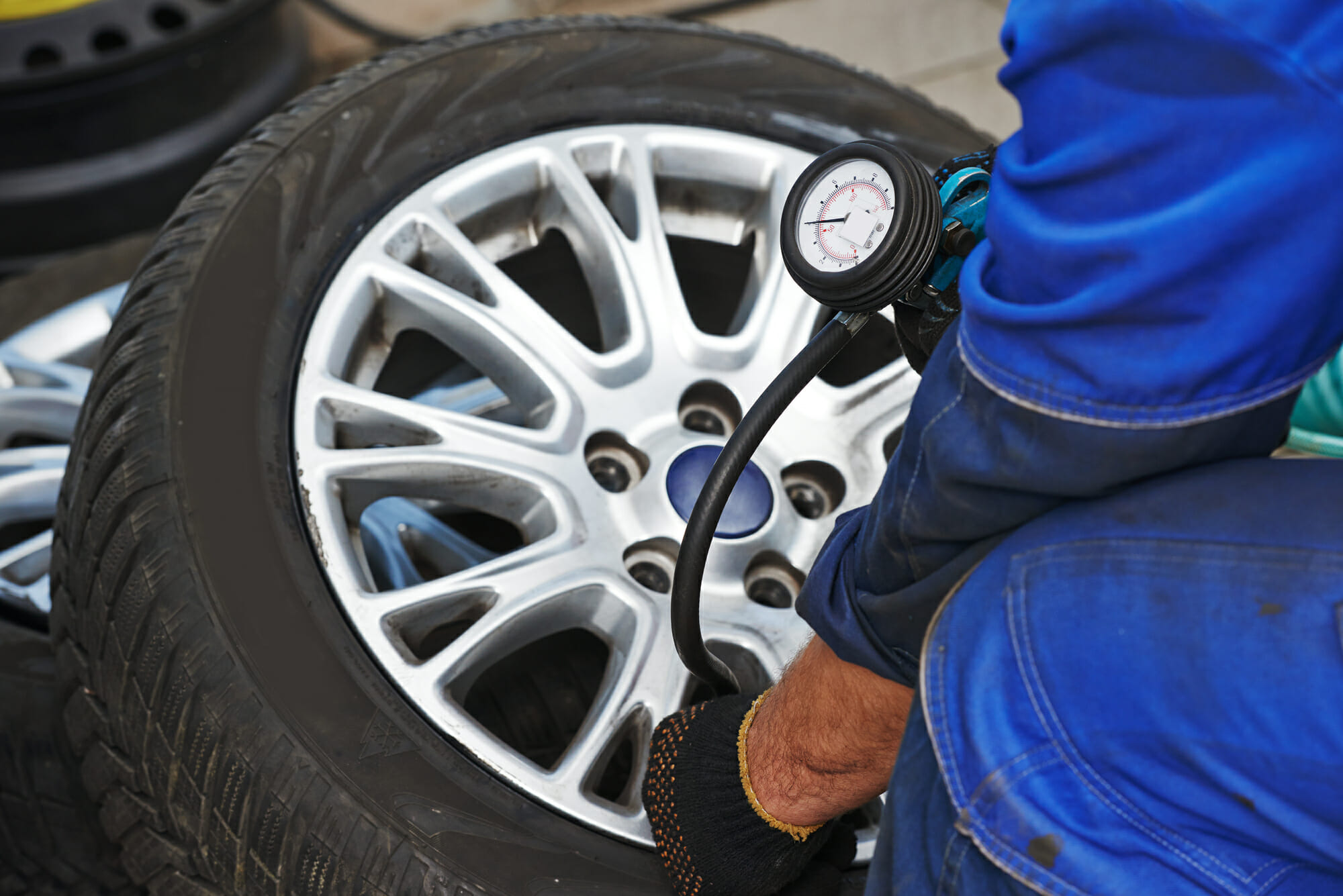 Auto Mechanic Checking Tire Pressure