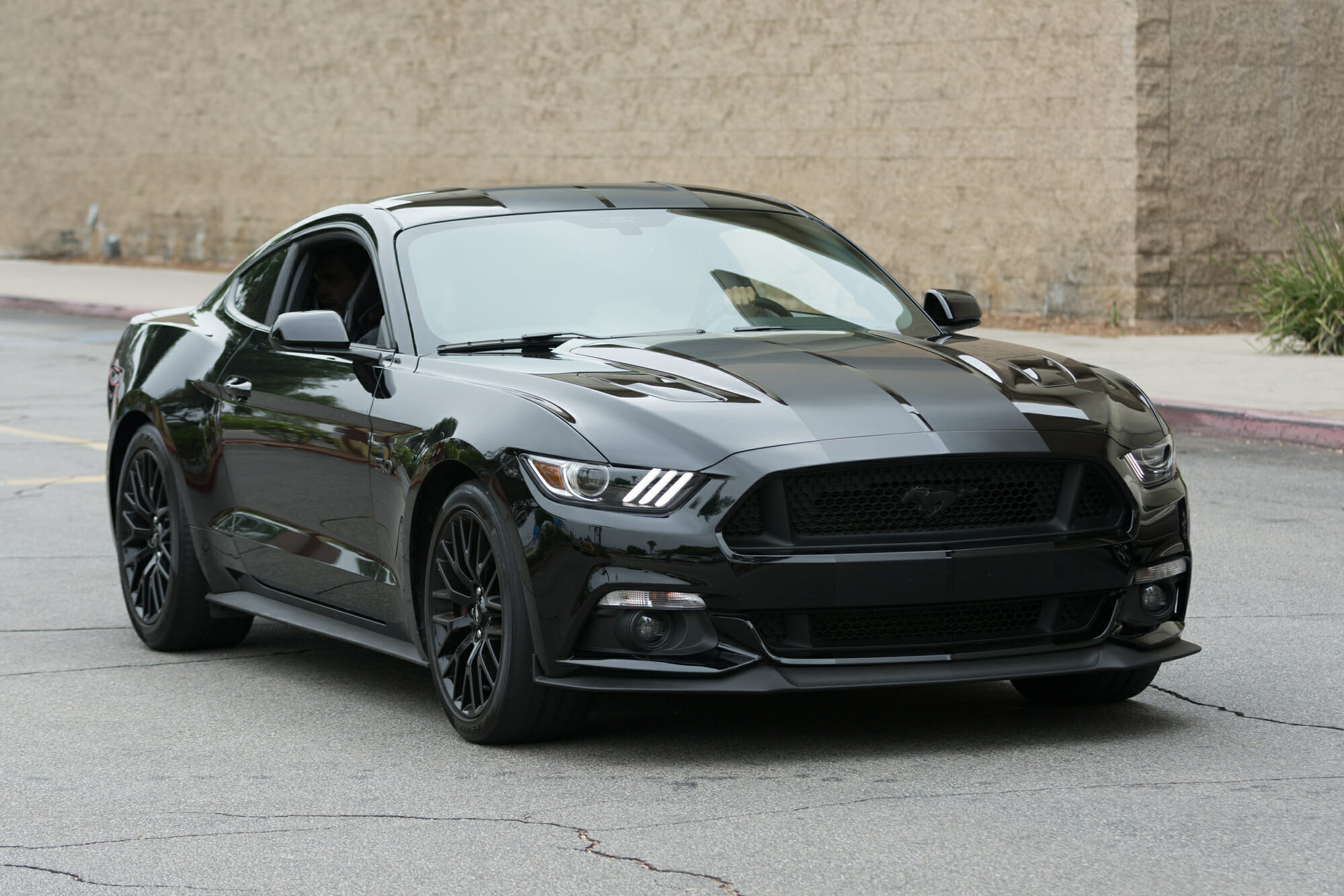 Black Ford Mustang GT with 5.0 V8 on city street