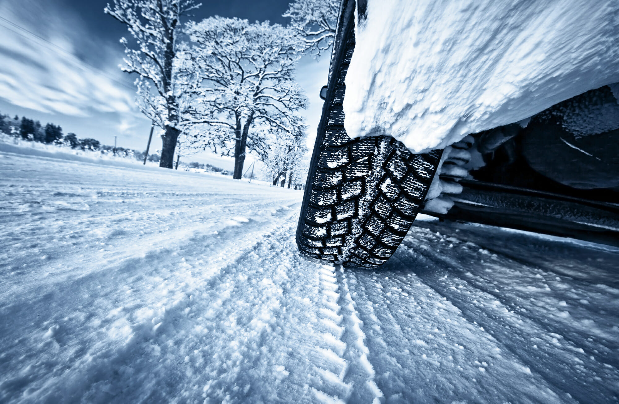 Closeup of winter tires driving through snow